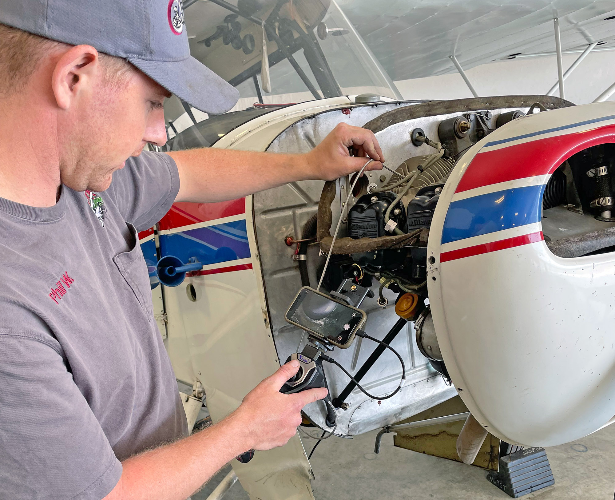 Savvy Borescope: A&P Phil Weaver of Northern Air Airmotive on the Boundary County, Idaho, airport using a Vividia CS-4010i borescope to examine a cylinder on an Aeronca Champ’s engine.
